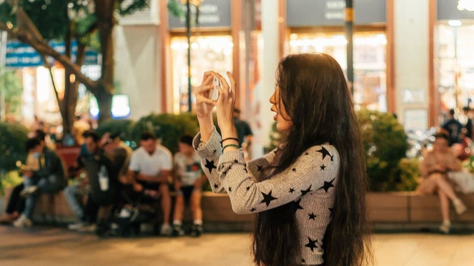 Source video: a creator filming on her phone in a city square